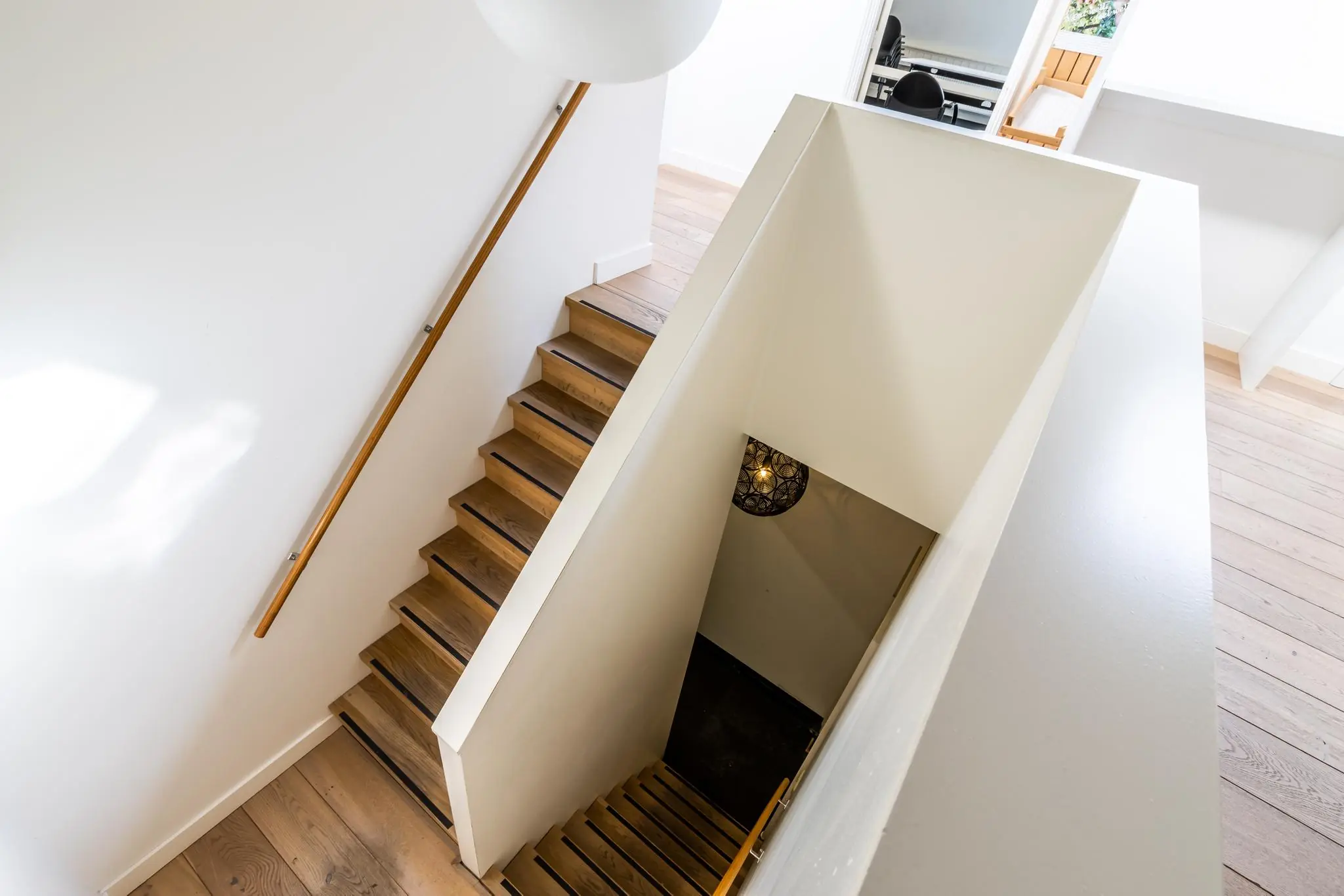 Houten trap met witte muren en een modern interieur in een woning aan de Langbroekerdijk A.